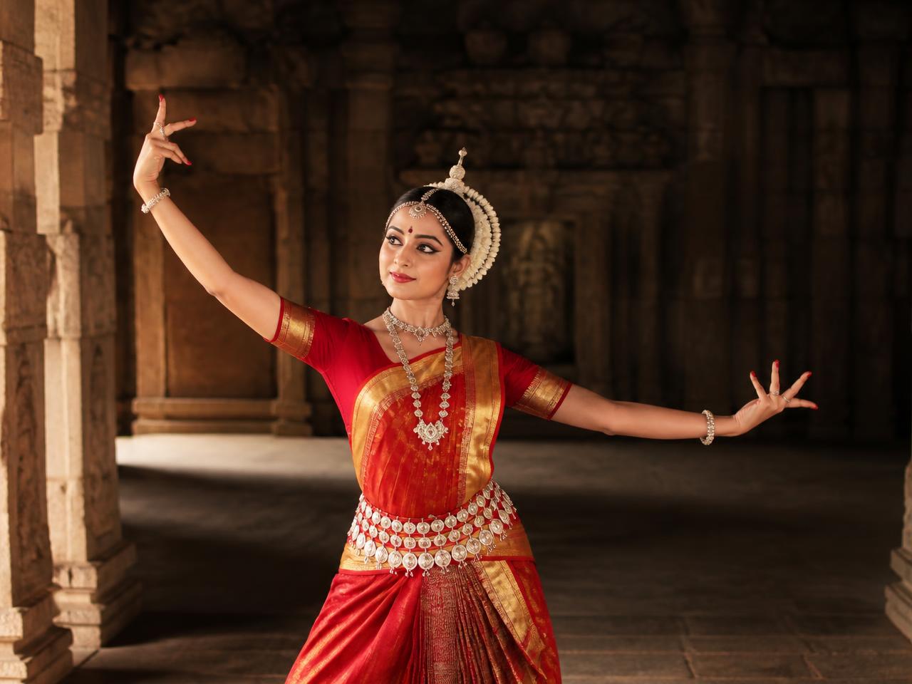 Odissi dancer performing in a temple hall